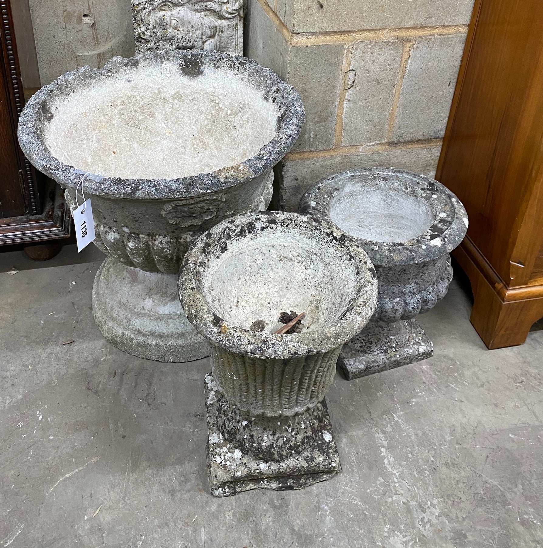 Three circular reconstituted garden urns, largest diameter 44cm, height 40cm